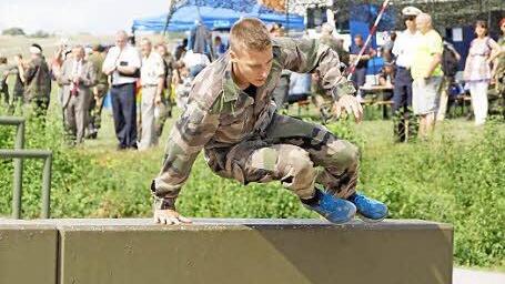 Ein französischer Reservist schwingt sich auf der Hindernisbahn über eine Mauer. Foto: Arkadius Guzy