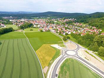 Fertiggestellt ist der erste Bauabschnitt der Umgehungsspange für Weismain. Der "Kreisverkehr Süd" (im Bild) mit seinen vier Abfahrtsästen ist hier gut zu sehen; der vierte Ast ragt derzeit noch in den Acker hinein, über ihn wird die eigentliche Umgehung angebunden. Im Hintergrund, im Bild oben links, ist die Baustelle zu sehen, wo eine der beiden Brücken über die Weismain errichtet wird. Foto: Marco Freitag MF drone flight