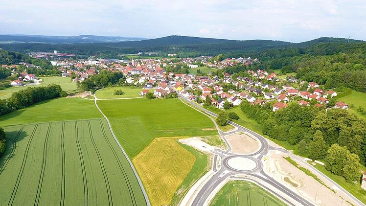 Fertiggestellt ist der erste Bauabschnitt der Umgehungsspange für Weismain. Der "Kreisverkehr Süd" (im Bild) mit seinen vier Abfahrtsästen ist hier gut zu sehen; der vierte Ast ragt derzeit noch in den Acker hinein, über ihn wird die eigentliche Umgehung angebunden. Im Hintergrund, im Bild oben links, ist die Baustelle zu sehen, wo eine der beiden Brücken über die Weismain errichtet wird. Foto: Marco Freitag MF drone flight