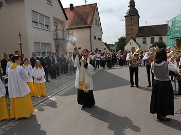 Pfarrer Matthias Steffel verleiht der sanierten Straße den kirchlichen Segen.  Foto: Mathias Erlwein