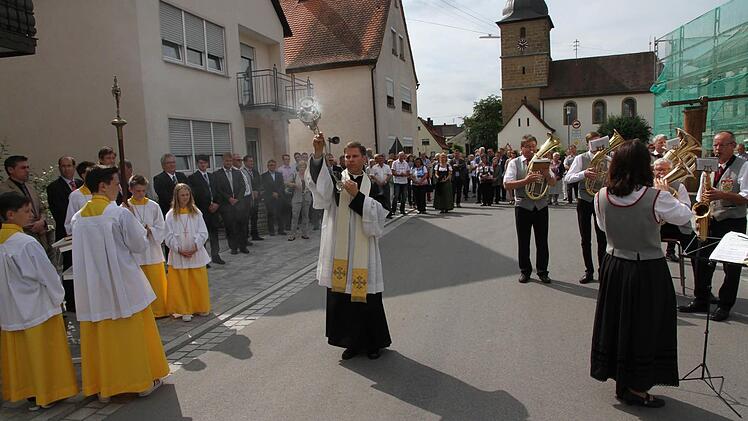 Pfarrer Matthias Steffel verleiht der sanierten Straße den kirchlichen Segen.  Foto: Mathias Erlwein