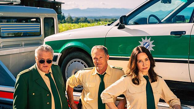 Der TV-Polizeiwagen von "Hubert ohne Staller", vor dem Reimund Girwidz (Michael Brandner, links), Franz Hubert (Christian Tramitz) und Sabine Kaiser (Katharina M&uuml;ller-Elmau) hier posieren, ist im Visier der echten Polizei.