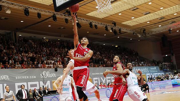 Der Bamberger Maodo Lo kommt  frei zum Korbleger, Robin Benzing (links daneben, fast verdeckt) ist machtlos. Rechts rangeln der W&uuml;rzburger Clifford Hammons und Augustine Rubit (rotes Trikot) um eine gute Reboundposition.