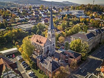 Aus der Vogelperspektive: die Martin-Luther-Kirche in Lichtenfels mit Pfarrhaus (vorne, Mitte) und Gemeindehaus (rechts), im Hintergrund der StaffelbergMorhard Architekturbüro / Klaus Wendel