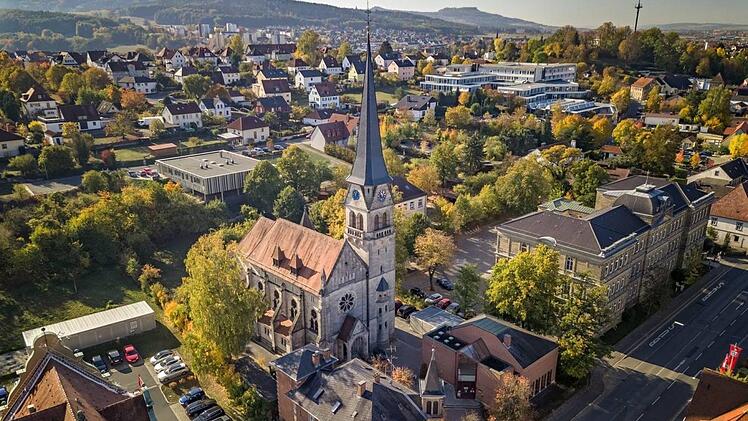Aus der Vogelperspektive: die Martin-Luther-Kirche in Lichtenfels mit Pfarrhaus (vorne, Mitte) und Gemeindehaus (rechts), im Hintergrund der StaffelbergMorhard Architekturbüro / Klaus Wendel