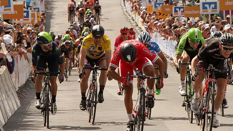 Zielsprint in Ebern: Während der spätere Sieger Sam Bennett (rechts) und der Franzose Nacer Bouhanni (rotes Trikot, daneben) noch um Platz 1 kämpfen, hat der deutsche Topstar John Degenkolb (Zweiter von links im Gelben Trikot) bereits erkannt, dass der Tagessieg für ihn diesmal nicht mehr drin ist.