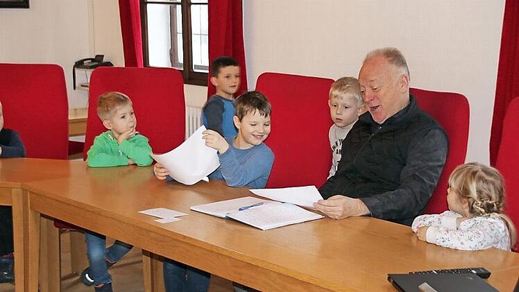 Bürgermeister Helmut Blank sieht sich die Zeichnungen an, die die Kindergartenkinder zum Thema Hundehaufen gemalt haben. Diese werden nun im Rathaus aufgehängt, die Münnerstädter sollen die schönsten küren.  Fotos: Thomas Malz