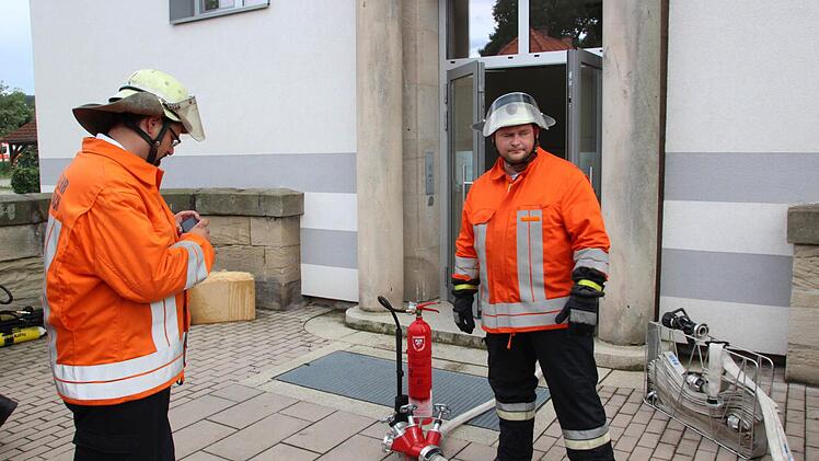 Die Feuerwehrmänner Stefan Wicklein (links) und Christian Reuß am Einsatzort, dem Nebeneingang der Lucas-Cranach-Schule.  Foto: Friedwald Schedel