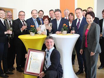 Die Mitarbeiter hatten zur Überraschung von Landrat Klaus Peter Söllner eine Feier organisiert. Hier stoßen die Gäste mit auf sein Jubiläum an. Unter den Gratulanten waren auch MdB Emmi Zeulner (links) und OB Henry Schramm (Fünfter von rechts). Foto: Alexander Hartmann