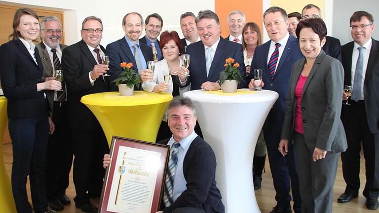 Die Mitarbeiter hatten zur Überraschung von Landrat Klaus Peter Söllner eine Feier organisiert. Hier stoßen die Gäste mit auf sein Jubiläum an. Unter den Gratulanten waren auch MdB Emmi Zeulner (links) und OB Henry Schramm (Fünfter von rechts). Foto: Alexander Hartmann
