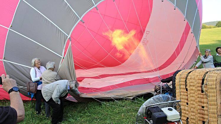 Der Ballon wird mit Heißluft gefüllt. Dabei helfen die Ballonfahrerinnen links und rechts des Brenners kräftig mit. Foto: Helmut Will