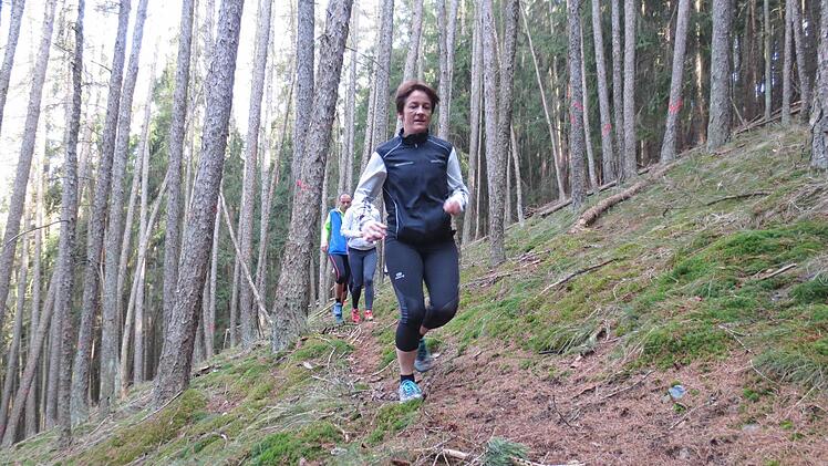 Ein schmaler Pfad schlängelt sich durch den Wald bei Guttenberg. Jutta Kratzel führt das Feld an. Foto: Michael Kraus
