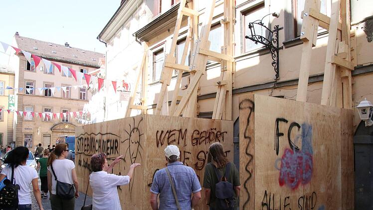 Gesprächsthema in Bamberg - auch ohne schwarze Graffiti-Schriftzüge - ist die hölzerne Stützkonstruktion, die das einsturzgefährdete Haus absichert. Foto: Sebastian Schanz