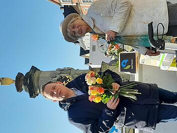 Bürgermeister Tobias Ehrlicher beim verteilen der fair gehandelten Rosen auf dem Marktplatz von Bad Rodach.