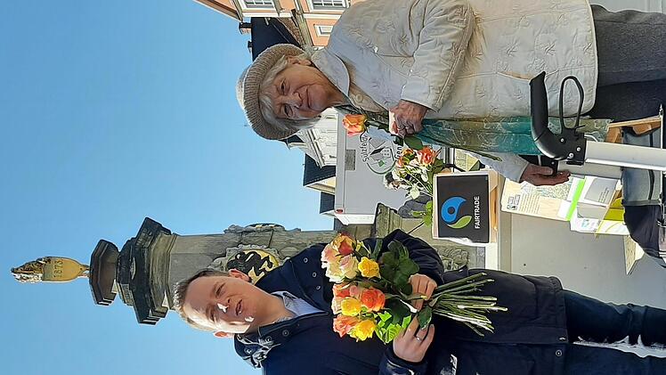 Bürgermeister Tobias Ehrlicher beim verteilen der fair gehandelten Rosen auf dem Marktplatz von Bad Rodach.