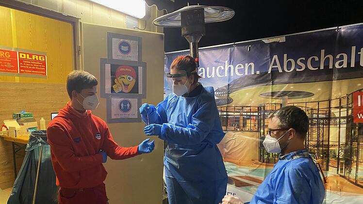 Jan Wehner, Christiane Bruns und Frank Wehner arbeiten ehrenamtlich an der Corona Teststrecke der DLRG vor der KissSalis Therme. (Foto: Angelika Despang)