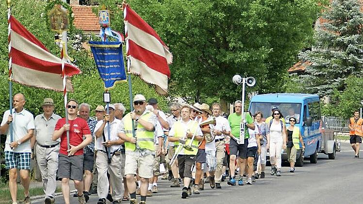Fast wieder daheim: Vom Geläut der Kapelle "Maria Heimsuchung" begleitet, ziehen die Wallfahrer durch Unterschleichach. Fotos: Sabine Weinbeer