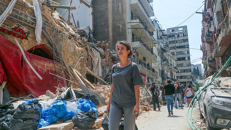 Eine Anwohnerin steht vor ihrem Haus im Stadtviertel Achrafieh, das durch die Explosion im Hafen schwer beschädigt wurde.  Foto: Naamani/dpa