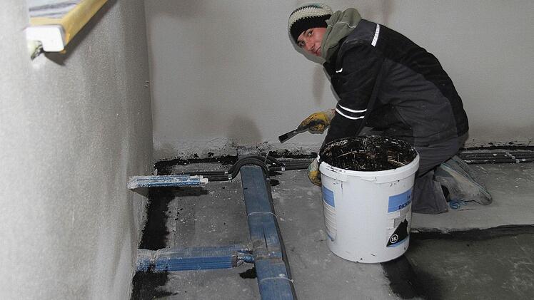 Nils Schmidt von der Firma Schwarz aus Weißenbrunn dichtet die Leitungen mit einer Bitumenschicht ab.