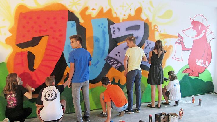Mit Hingabe sprayen die Fuchsstädter Jugendlichen eine Wand ihres künftigen Jugendzentrums im Mehrgenerationenhaus "Eulentreff".