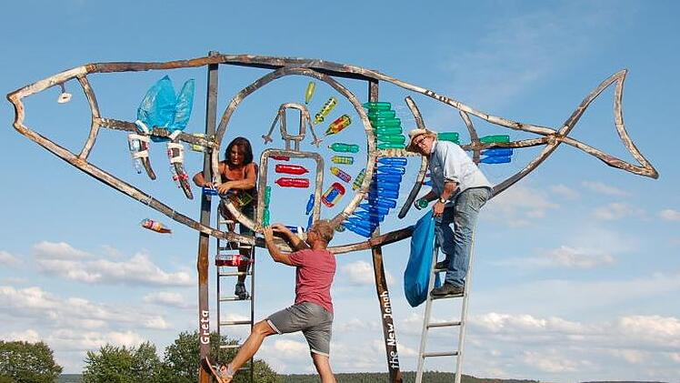 Mit Unterstützung von Bettina Schmidt und Wolfgang Will schuf der Berliner Künstler Herbert "Jimmy" Fell (mit Hut) eine neue Skulptur am "Dicken Turm" in Niederlauer. Foto: Manfred Mellenthin
