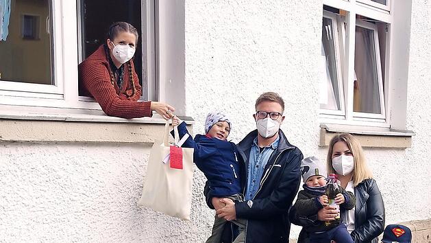 Die Familie Daum nimmt ihre „Picknick to go“-Tüte am Regenbogenfenster der „Villa Sonnenschein“ in Empfang.