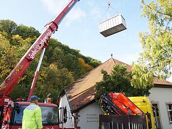 Der Kran hievt einen der Container übers Gebäude. Foto: Arkadius Guzy