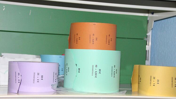Münzrollenpapier. Lila steht für Zwei-Euro-Stücke, grün für 50-Cent-Stücke. Foto: Simone Bastian