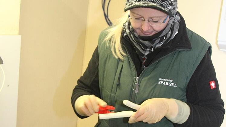 Martina Engel kontrolliert den geschälten Spargel und arbeitet per Hand noch einmal nach. Foto: Sonny Adam