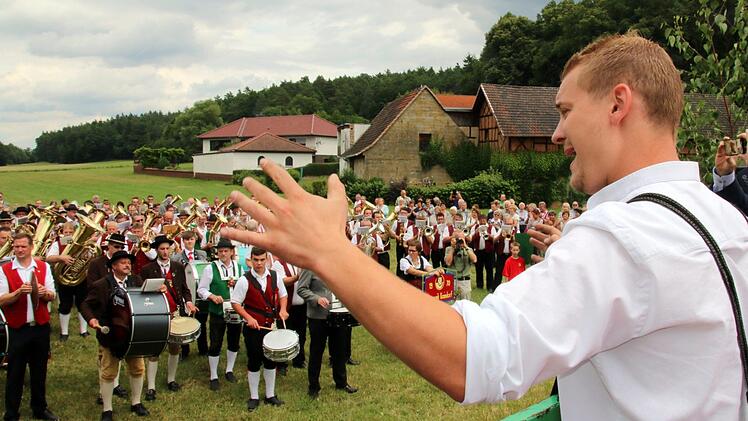 Sascha Dalke, Dirigent der gastgebenden Blaskapelle Neundorf, war es vorbehalten das erste Stück des Gemeinschaftschores zu dirigieren. Foto: Bettina Knauth