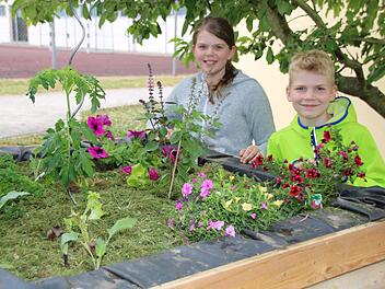 Anna Ohnemüller und Max Teichmann von der Grundschule Melkendorf sind stolz auf ihr fertig bepflanztes Hochbeet.Dagmar Besand