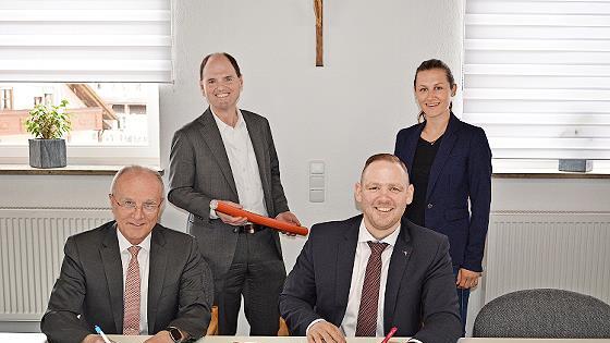 Bei der Unterzeichnung (v. l.): Bürgermeister Markus Grüner, MdL Michael Hofmann (mit Glasfaserlehrrohr), Regio-Manager Enrico Delfino (Telekom) und Key-Account-Managerin Technik Svenja Herrmann (Telekom)