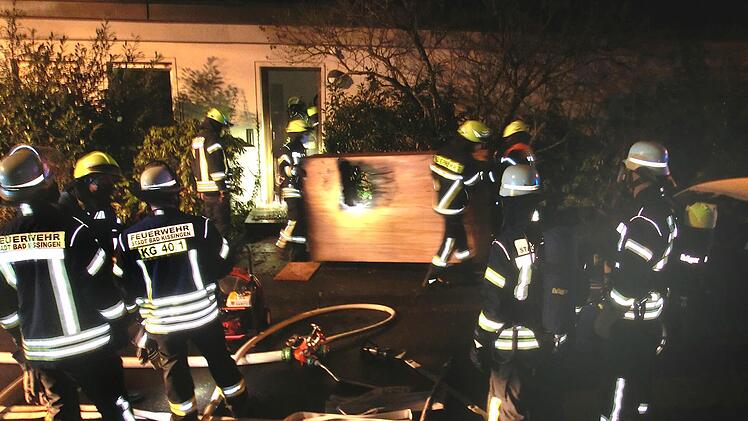 Ein am Abend nicht gelöschtes Teelicht löste in der Nacht  auf Montag in der Schillerstraße  in Bad Kissingen einen Zimmerbrand aus, bei dem die Wohnungsinhaberin  leicht verletzt wurde. Der noch kokelnde Schrank wird hier von den Floriansjüngern  ins Freie gebracht. Foto: Peter Rauch