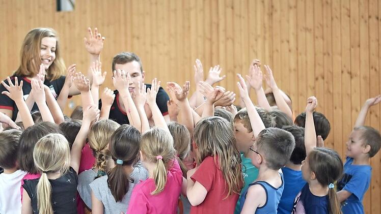 Zum Sport geh&ouml;rt das Abklatschen. Die Kinder machten gerne die sportlichen &Uuml;bungen mit. Die Basketball-Jugendtrainer (hinten links Jule Gese) verstanden es, die Eberner Kinder zu motivieren. 190 Buben und M&auml;dchen bekamen so ein sportliches Extratraining. Foto: Lina Ahlf