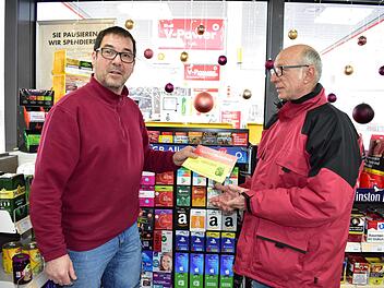 Klaus Wölfel, der Besitzer der Shell-Tankstelle in  Igensdorf, nimmt von seinem Kunden Gregor Mirsberger die zu Weihnachten  erhaltenen Gutscheine entgegen. Gutscheine sorgen in vielen regionalen Geschäften für einen Boom nach Weihnachten. Foto: Petra Malbrich