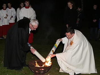Ein bewegender Moment in der österlichen Lichtfeier, die die Obere Pfarre ökumenisch mit St. Stephan begeht: Pfarrer Matthias Bambynek und Pfarrer Walter Neunhoeffer entzünden am Osterfeuer die jeweilige Osterkerze.  Foto: Karl Zimmermann