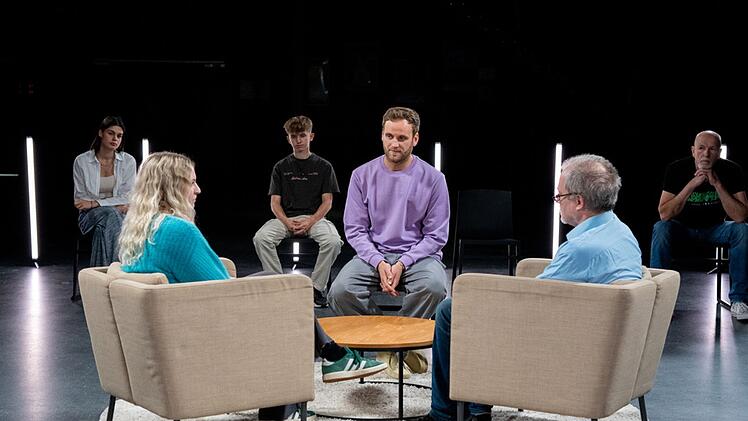 Psychologe Leon Windscheid (Mitte) spricht mit Teilnehmenden eines Rollenexperiments &uuml;ber ihre Vater-Kind-Beziehungnen.