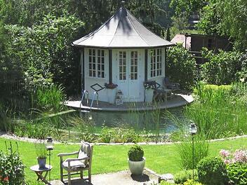 Ein Beispiel für gelungene Gartenplanung. Der Schwimmteich rund um den Pavillon wurde von Droll & Lauenstein gestaltet.