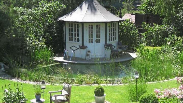 Ein Beispiel für gelungene Gartenplanung. Der Schwimmteich rund um den Pavillon wurde von Droll & Lauenstein gestaltet.