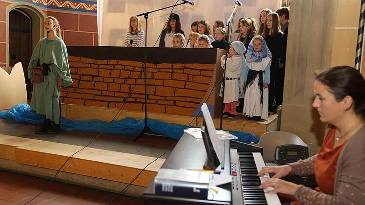 Die Geschichte von Jona (grünes Kleid) führten 18 Kinder und Jugendliche in Hetzelsdorf auf. Begleitet wurden sie von Johanna Spindler an der Orgel (re.). Foto: Franz Galster
