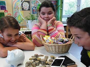 Hannah, Mina und Ramon überlegen sich, was sie mit dem Ersparten kaufen können. Foto: Gerlach-Hirt