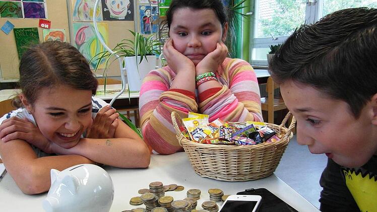 Hannah, Mina und Ramon überlegen sich, was sie mit dem Ersparten kaufen können. Foto: Gerlach-Hirt