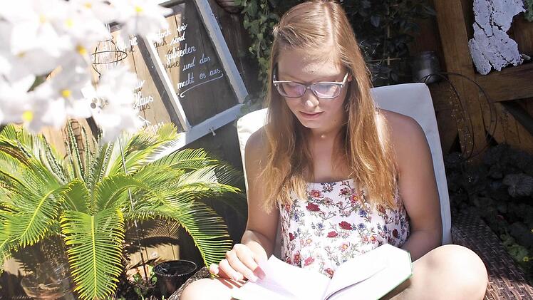 Marina Bräutigam genießt das Wetter auf der Terrasse. Um in der Berufsschule besser mitzukommen, hat sie sich ein spezielles Buch gekauft. Denn in der Realschule konnte sie noch keine tieferen Kenntnisse in Sachen Buchhaltung erlangen. Die wird sie aber bald brauchen.  Foto: Lisa Kieslinger
