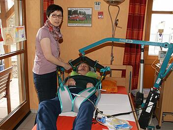 Fast eine Viertelstunde benötigt Monika Betz trotz Lift und Routine, um ihren Mann aus dem Rollstuhl ins Bett zu bringen. Nach zwei bis drei Stunden wird für den Wachkoma-Patienten das Sitzen zu anstrengend. Nicht nur zu liegen ist aber wichtig vor allem für die Lungenfunktion.  Foto: Sabine Weinbeer