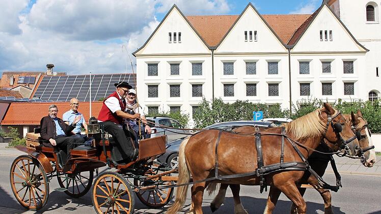 Pfarrer Wolfgang Schmidt mit Bürgermeister Jakobus Kötzner hinten in der Kutsche. Hans Müller auf dem Kutschbock lenkte das Gespann. Daneben Frensdorfs Zweiter Bürgermeister Norbert Neundorfer. Im Hintergrund die Frensdorfer Pfarrkirche, über drei Jahrzehnte Wirkungsstätte des Pfarrers im Ruhestand Foto: see