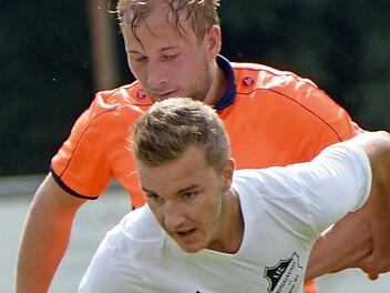 Der vierfache Kleintettauer Torsch&uuml;tze Andreas B&ouml;hnlein (hinten) versucht vergebens an den Ball zu kommen, den der Burgkunstadter Maximilian Stammberger abschirmt.  Foto: Gunther Czepera