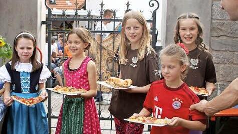 Früh übt sich: Diese Mädchen griffen engagiert ein und betätigten sich als Helferinnen für die Darreichung von Pizza und Zwiebelkuchen.