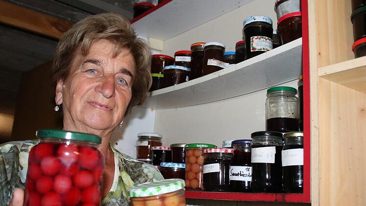 Irmgard Heinrich zeigt eine Auswahl an Gläsern mit eingemachtem Obst. Foto: Ralf Ruppert