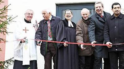 Pfarrer Gerhard Möckel (von links), Initiator Alois Dechant, Pfarrerin Claudia Jobst, Hermann Schuberth und Stefan Krug von der Regierung sowie Ibrahim Kefci von islamischen Gemeinde in Kulmbach durchschnitten ein Band im Eingangsbereich. Foto: Stefan Lutter