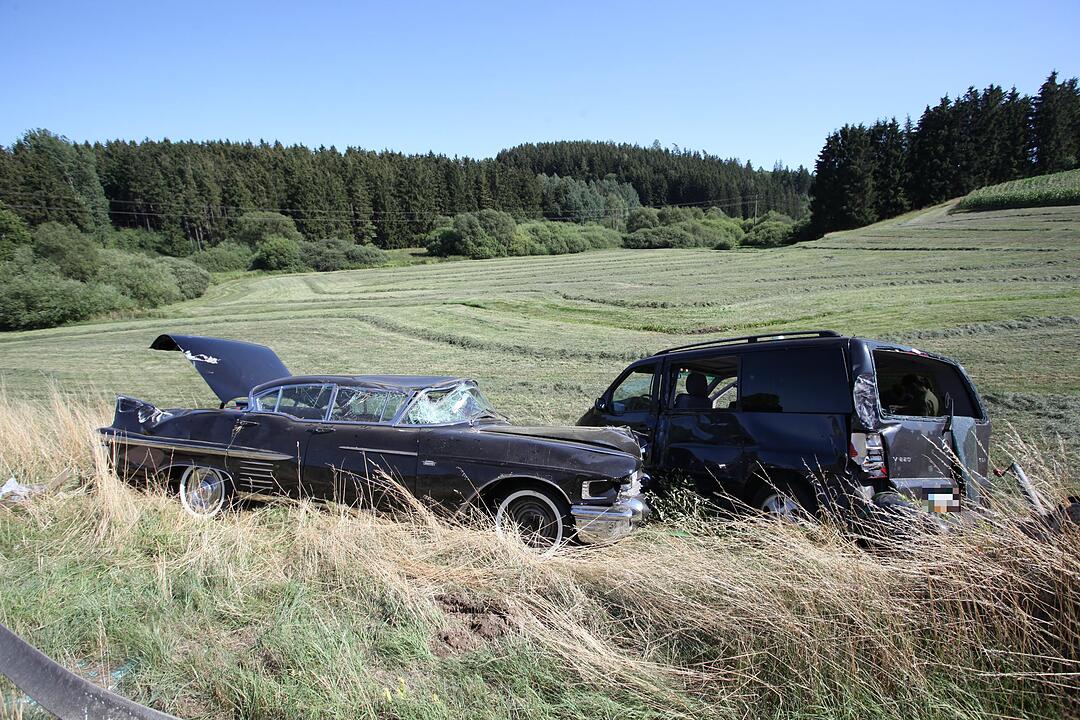 Mit Cadillac beladener Auto-Anhaenger kommt von der Fahrbahn ab